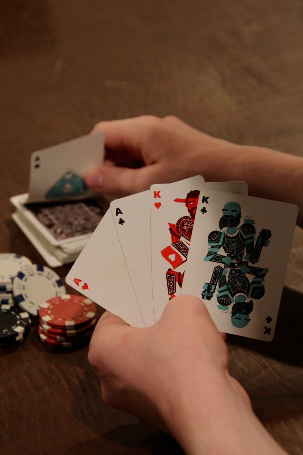 Kartu remi dan tumpukan chip poker di atas meja hijau