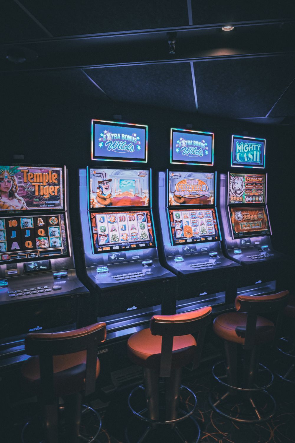 Mesin slot modern dengan layar menyala di lantai kasino